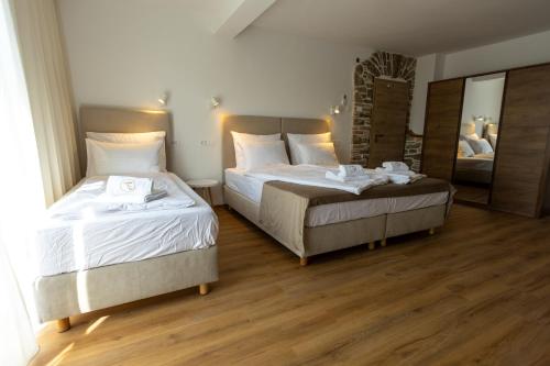 a bedroom with two beds and a mirror at Bed & Breakfast Adelsberg Inn in Postojna
