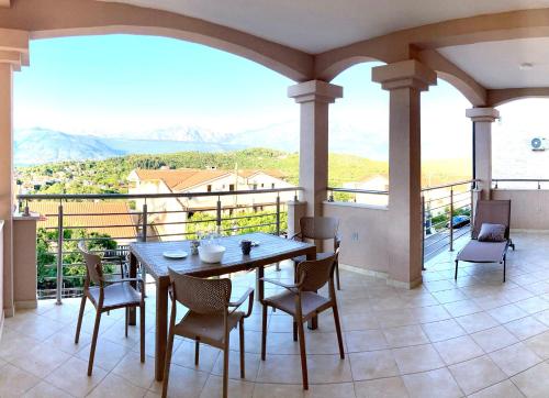 a table and chairs on a balcony with a view at Apartments Amilija in Radovići