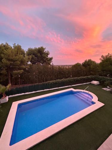 a swimming pool in a yard with a sunset at Chalet con piscina privada en Alcocebre in Alcossebre