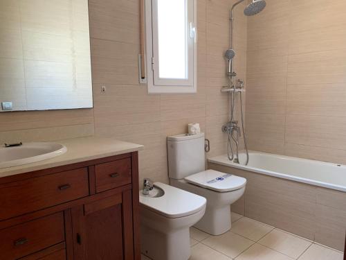 Un baño con inodoro, lavabo y bañera. en House with pool in Pino Alto, en Mont-roig