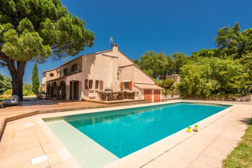 une image d'une piscine en face d'une maison dans l'établissement Vue mer 360 La Cataline, à Bormes-les-Mimosas