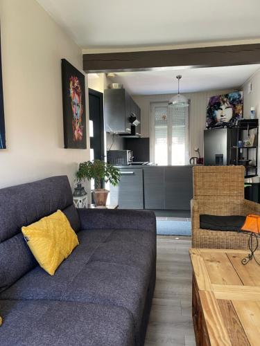 un salon avec un canapé et une cuisine dans l'établissement Agréable maison de ville à Pacy sur eure, à Pacy-sur-Eure