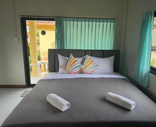 a bedroom with a large bed with two pillows at Thungwua laen resort in Chumphon