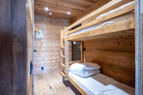 a couple of bunk beds in a wooden room at Appartement 6p Au Pied Des Pistes in Val Thorens