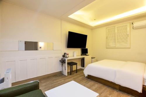 a hotel room with a bed and a tv at Anyang Sky Castle in Anyang