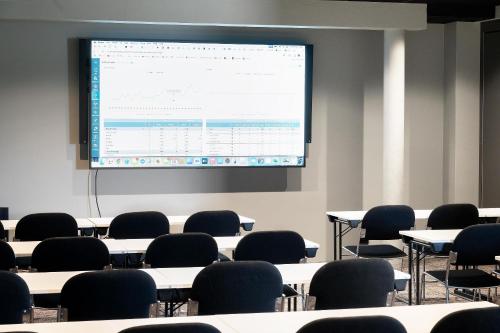 a classroom with tables and chairs and a projection screen at Best Western Plus Oslo Airport in Gardermoen