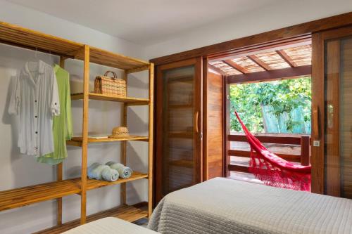 a bedroom with a bed and a window at Chalé Coruja - Taipu com Piscina in Marau