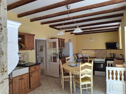 une cuisine avec une table et des chaises dans une pièce dans l'établissement Les Volets Verts, ROUSSINES, CHARENTE, 16310 FRANCE, à Roussines