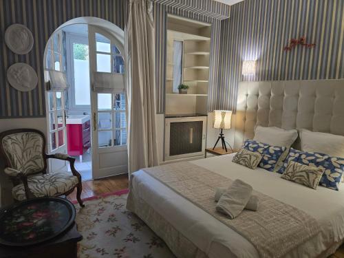 une chambre avec un grand lit et une chaise dans l'établissement Bel appartement, à Beaune