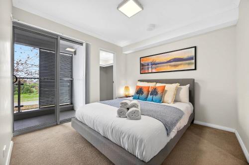 a bedroom with a large bed and a window at Coastal Comfort in Rockingham 2BR Apartment with Parking & Balcony in Rockingham