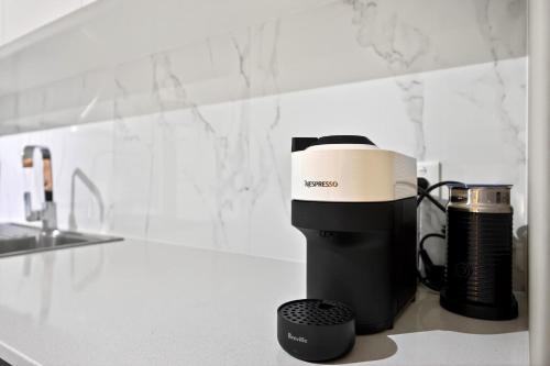 a coffee maker sitting on a counter in a kitchen at Coastal Comfort in Rockingham 2BR Apartment with Parking & Balcony in Rockingham