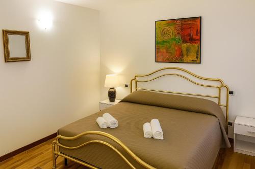 ein Schlafzimmer mit einem Bett mit zwei Hausschuhen darauf in der Unterkunft Ca' De Mezo near San Marco in Venedig