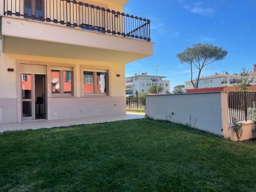 a house with a fence and a yard at Casa Junea in Maccarese