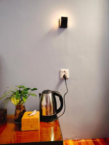 a tea kettle sitting on a table next to a lightswitch at Shova's Home Stay in Kathmandu