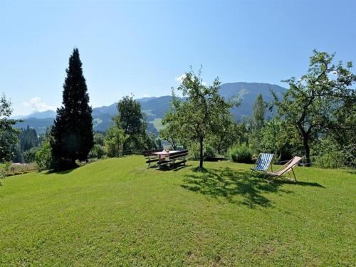 two chairs and a picnic table on a grass field at Oberseebachhof in Scheffau am Wilden Kaiser