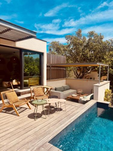 un patio avec une table et des chaises et une piscine dans l'établissement Aria Cigala, à Bonifacio