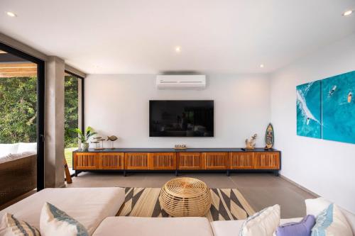 a living room with a flat screen tv on a wall at Villa Kañik - Luxury Retreat with Concierge Services in Dominical