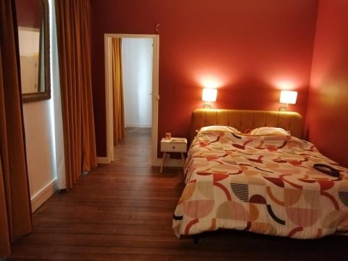 Un dormitorio con una cama y una pared roja. en Damalix, en Saint-Maurice