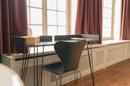 a table with a chair in front of a window at Hotel Restaurant Steenhuyse in Oudenaarde