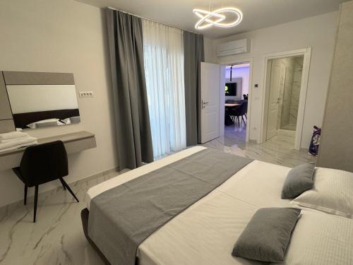 a bedroom with a bed and a desk and a mirror at Villa Violeta & Katharina in Rovinjsko Selo