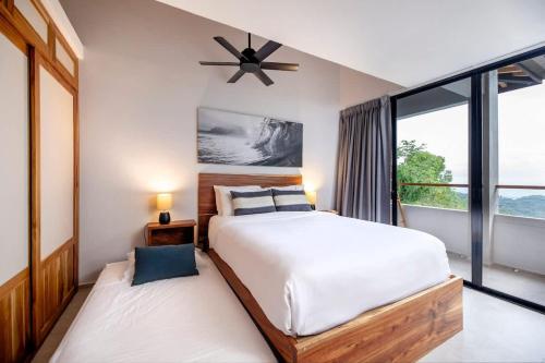 a bedroom with two beds and a large window at Villa Kañik - Luxury Retreat with Concierge Services in Dominical