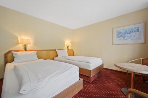 a hotel room with two beds and a table at Schwarzwaldapartment Nr 27 30qm Zwei Einzel Betten Rustikal in Altensteig