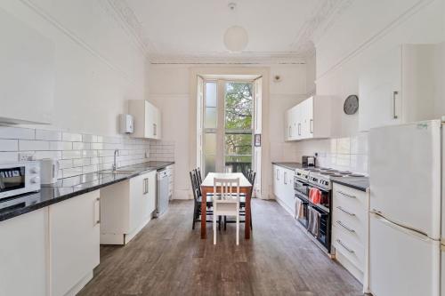 a kitchen with white appliances and a table and chairs at No 64 Georgian House - By Clifton Short Lets in Bristol