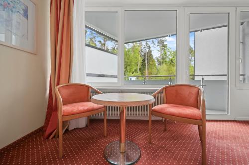 a room with two chairs and a table and a window at Schwarzwaldapartment Nr 27 30qm Zwei Einzel Betten Rustikal in Altensteig