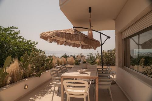 a patio with a wooden table and chairs and a window at Aerides Luxury Villa in Paleo Tsifliki
