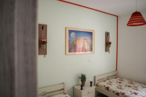 a bedroom with a bed and a picture on the wall at Eirini's apartment in Kanali