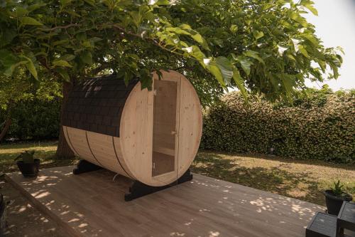 a wooden barrel sitting on a wooden deck under a tree at Aerides Luxury Villa in Paleo Tsifliki