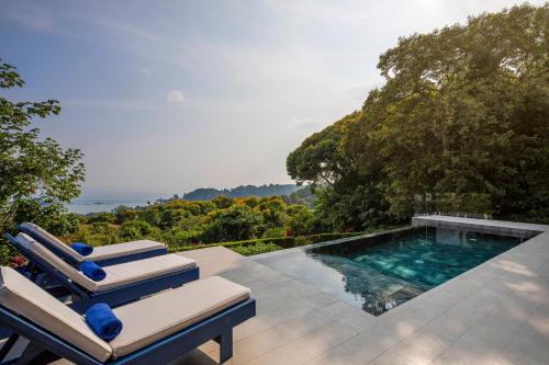 a swimming pool with two lounge chairs next to it at Villa Kañik - Luxury Retreat with Concierge Services in Dominical