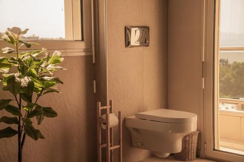 a bathroom with a toilet and a plant in it at Aerides Luxury Villa in Paleo Tsifliki
