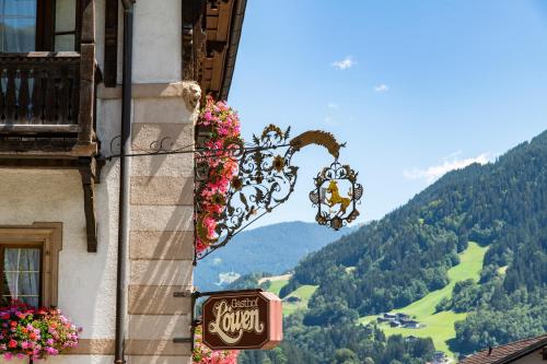 a sign on a building with a view of a mountain at Gasthof Löwen by Hotel Montafoner Hof in Schruns-Tschagguns