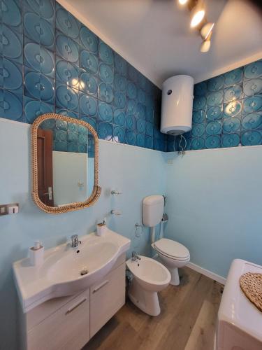 a bathroom with a sink and a toilet and a mirror at Aperitivo in Scalea