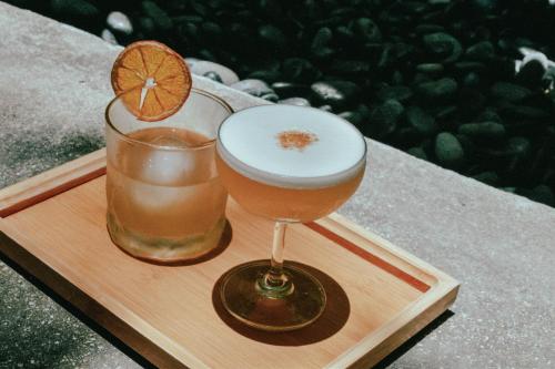 two drinks on a wooden tray with an orange slice at SI Hotel in Taichung