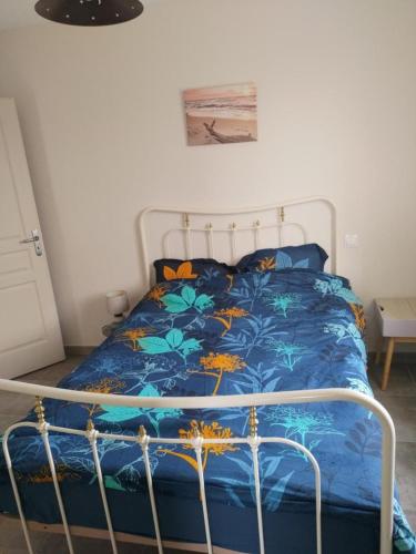 a bedroom with a bed with a blue comforter at APPARTEMENT PRES DE ROYAN 7 MINUTES MER CONFORT CALME rdc espace détente jardin in Sémussac