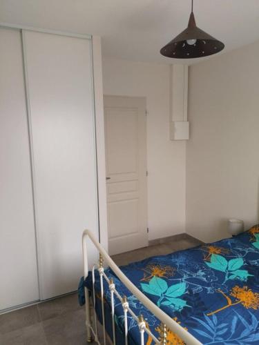 a bedroom with a bed in a room with a door at APPARTEMENT PRES DE ROYAN 7 MINUTES MER CONFORT CALME rdc espace détente jardin in Sémussac