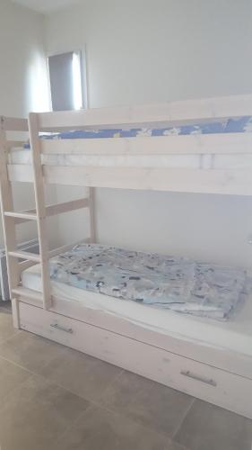 a white bunk bed with the bottom bunkitures at APPARTEMENT PRES DE ROYAN 7 MINUTES MER CONFORT CALME rdc espace détente jardin in Sémussac