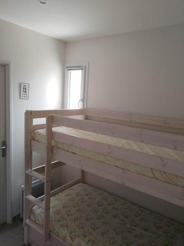 a bedroom with two bunk beds and a window at APPARTEMENT PRES DE ROYAN 7 MINUTES MER CONFORT CALME rdc espace détente jardin in Sémussac