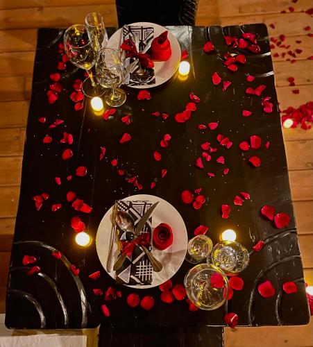 a table with wine glasses and red hearts on it at Eagle View Lodge - Kigali in Kigali