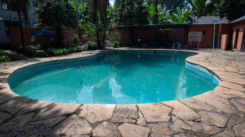 a swimming pool with blue water in a yard at Vijiji Center Lodge and Safari in Arusha