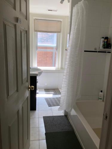 a bathroom with a shower and a tub and a window at Highland Park Pittsburgh in Pittsburgh