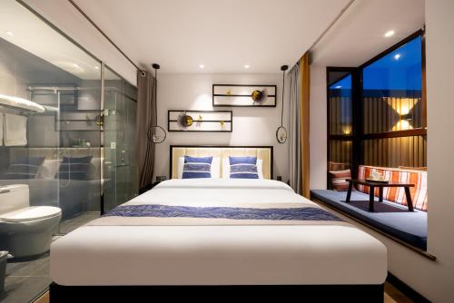 a bedroom with a king sized bed and a bathroom at Beijing Tangfu Nanluoguxiang Tian an Men Lama Temple San Li Tun Snack Street Hotel,Free Laundry Dry Service and Free Afternoon Tea &professional Free Tour Ticket Service with English Speaking Staff in Beijing