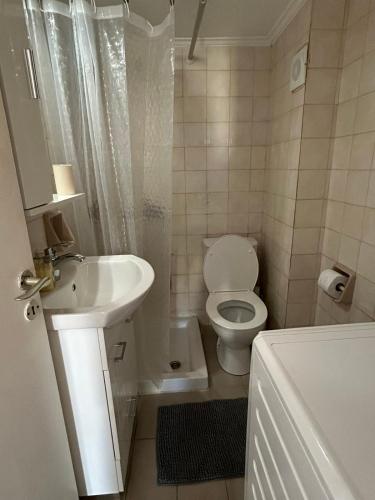 a white bathroom with a toilet and a sink at Moderna Yaya - Andros Chora in Andros