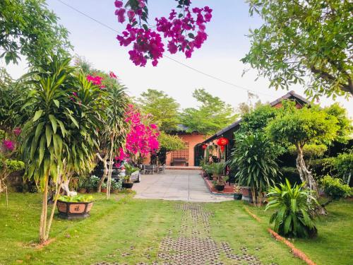 a house with trees and flowers in the yard at Ho Tram Chill House in Xuyên Mộc