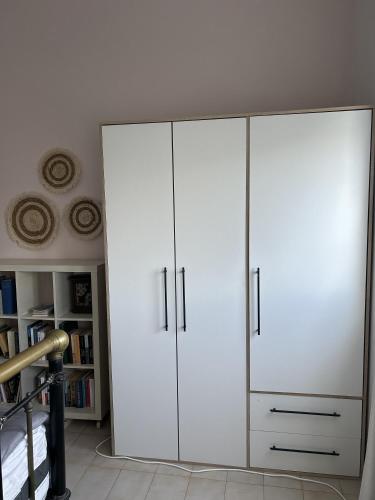 a white cabinet with two doors in a room at Moderna Yaya - Andros Chora in Andros