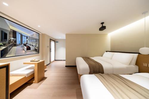 a hotel room with two beds and a tv at Beijing Tangfu Nanluoguxiang Tian an Men Lama Temple San Li Tun Snack Street Hotel,Free Laundry Dry Service and Free Afternoon Tea &professional Free Tour Ticket Service with English Speaking Staff in Beijing