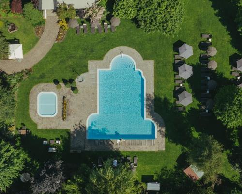 an aerial view of a pool in a yard with a fountain at Ferien & Wellnesshotel Windschar in Brunico