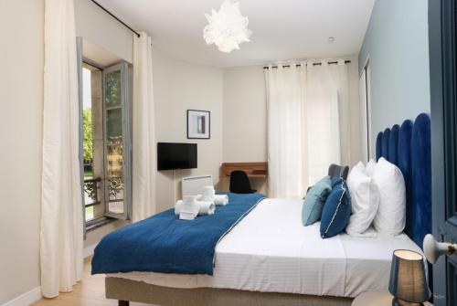 une chambre avec un grand lit avec des oreillers bleus et blancs dans l'établissement Cèl Ethéré by Rahault, à Carcassonne